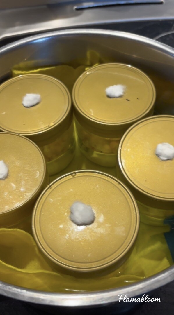 Các lọ ngô có nắp lọc cotton được đặt trong nồi nước để xử lý nhiệt.